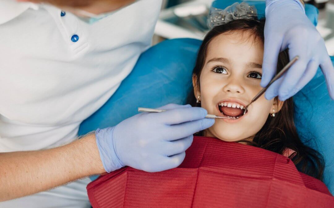 a smiling young girl undergoing a dental exam