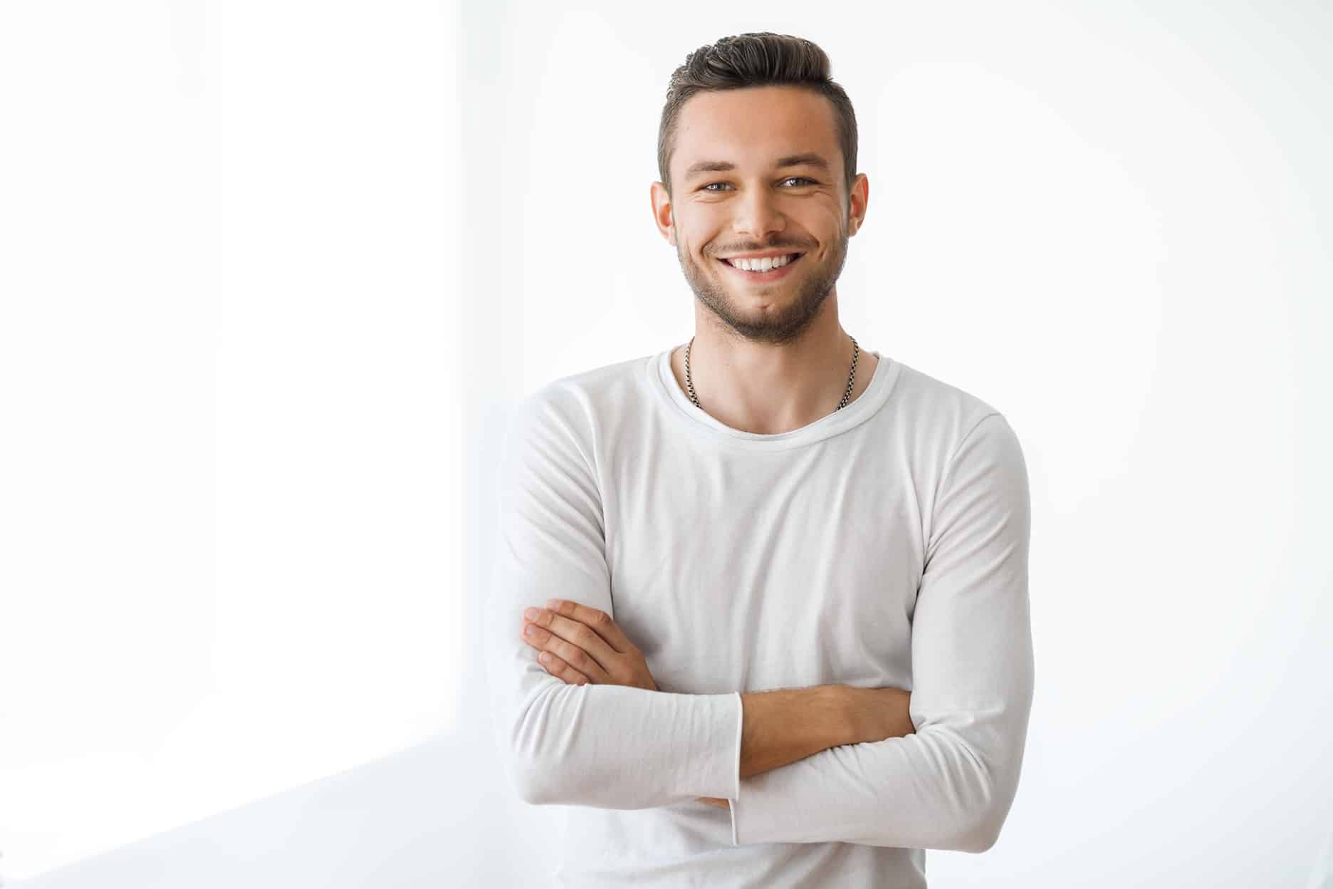 man smiling with arms crossed - Nouvelle Dentistry